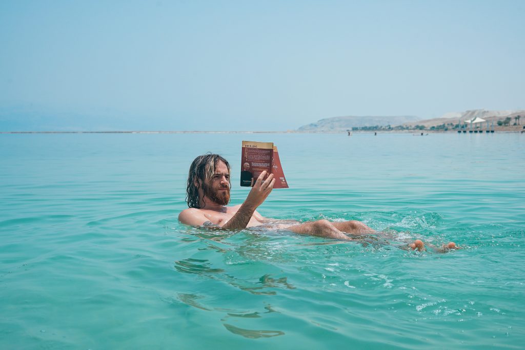 Man floating in the ocean reading a book